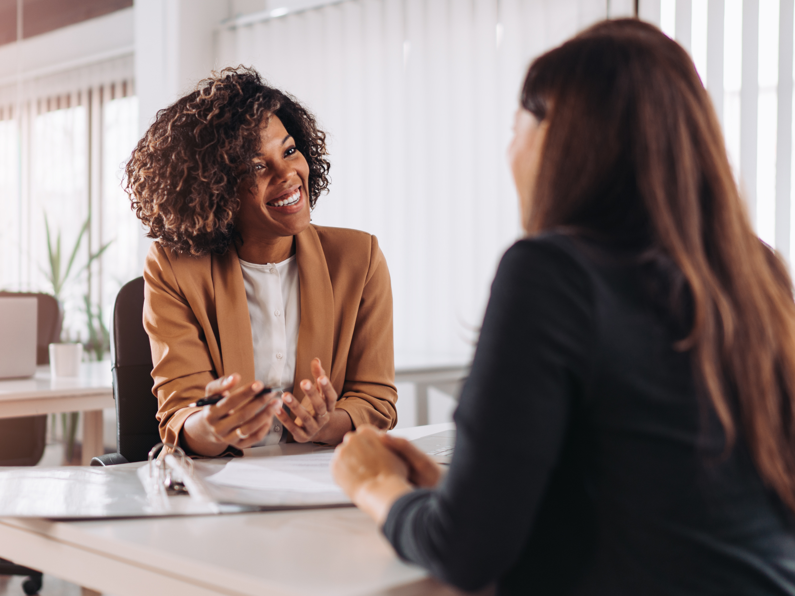 Two women engaged in conversation, representing dialogue and personalized relevance.